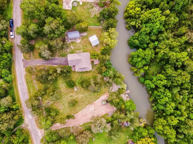 an aerial view of residential house with outdoor space and trees all around
