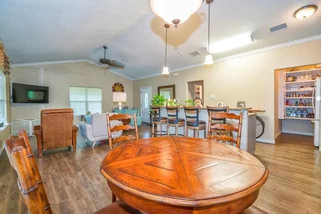 a view of a dining room with lots of furniture and wooden floor