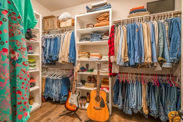 a view of walk in closet with clothes and shoes