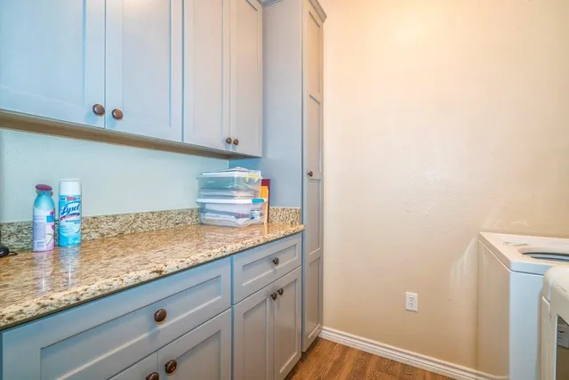 a kitchen with granite countertop white cabinets and a sink