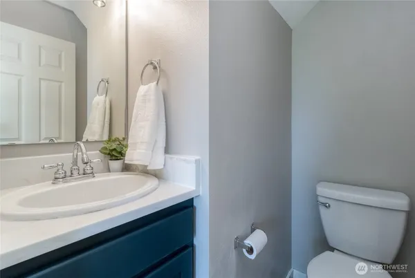 a bathroom with a toilet a sink and mirror