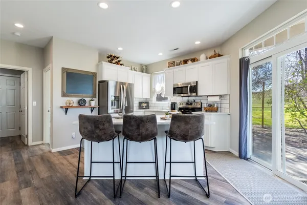 a living room with furniture a flat screen tv and a refrigerator
