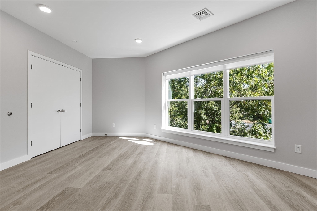 59 Mill Street, Unit 116 Woburn, MA 01801 - Photo 12 of 23 a view of an empty room with wooden floor and a window
