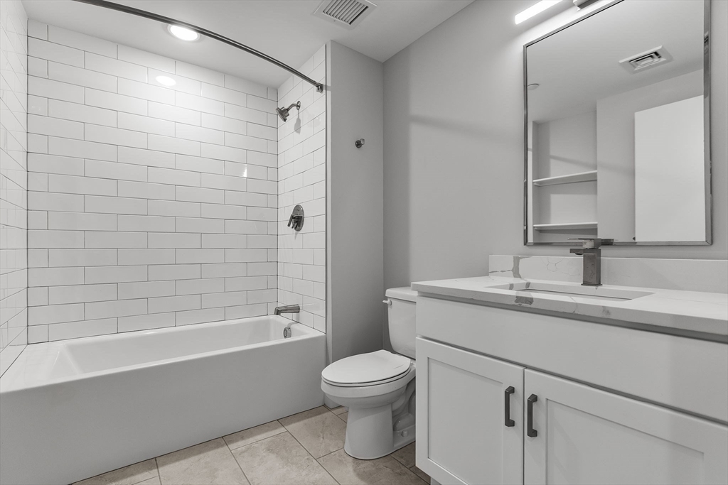 59 Mill Street, Unit 116 Woburn, MA 01801 - Photo 16 of 23 a bathroom with a toilet a sink and a bathtub