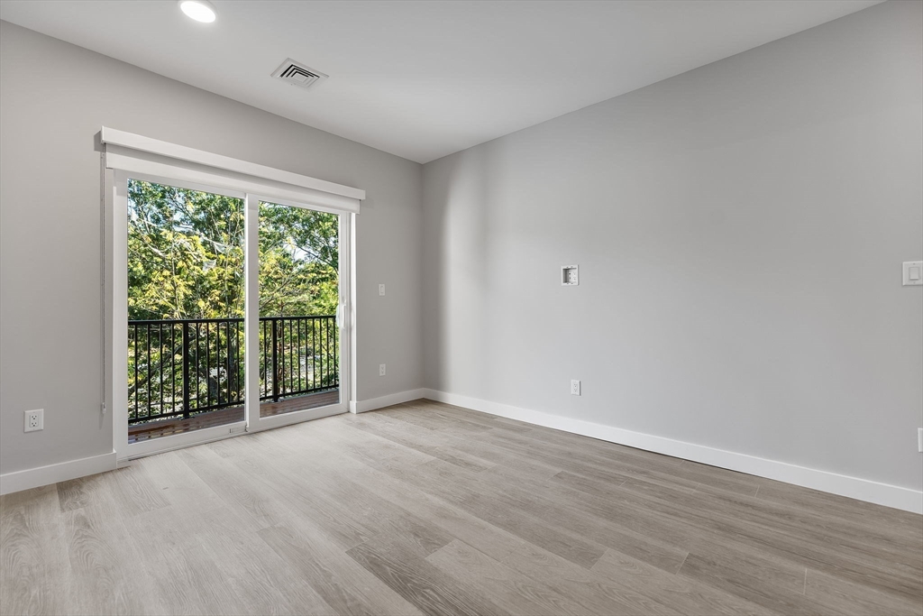 59 Mill Street, Unit 116 Woburn, MA 01801 - Photo 20 of 23 a view of an empty room with wooden floor and a window
