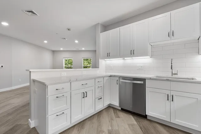 a kitchen with granite countertop white cabinets and a sink