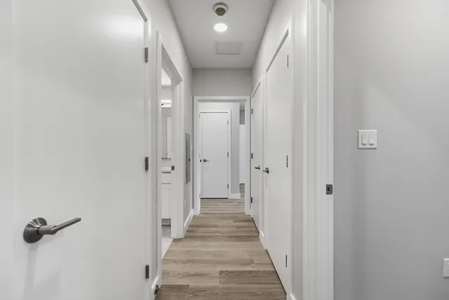 a view of a hallway with wooden floor and closet