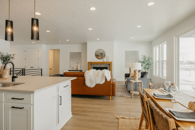 1066n South State Road, Unit ATWOOD Salem, UT 84653 - Photo 12 of 29 Open-concept living area featuring an eat-in kitchen island with pendant lighting, a fireplace with a wood-finish mantel, and wood-finish flooring