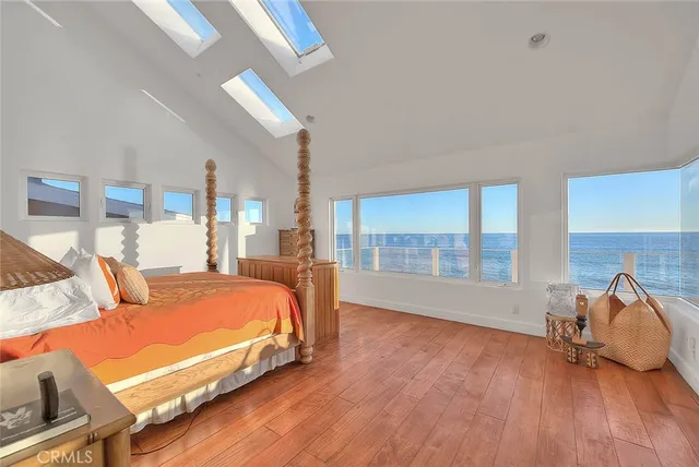 a bedroom with a bed a dresser with wooden floor