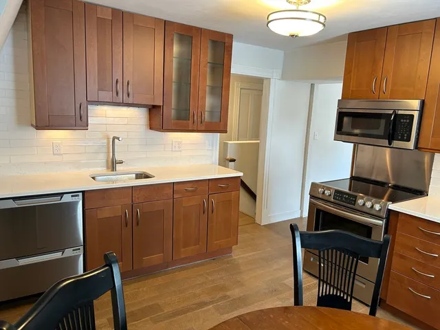 a kitchen with wooden cabinets a stove and a sink