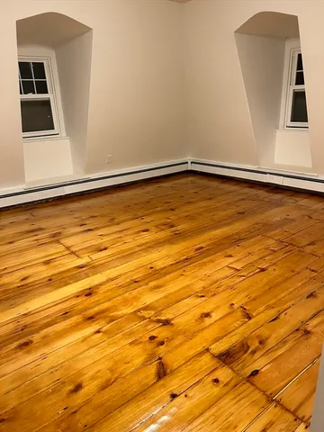 a view of a room with wooden floor and a window