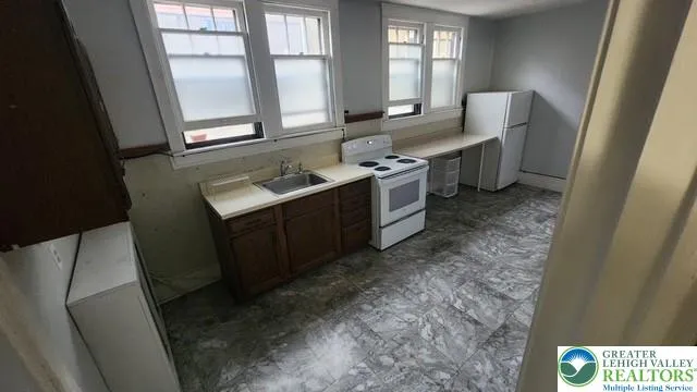 a bathroom with a sink toilet double vanity and window