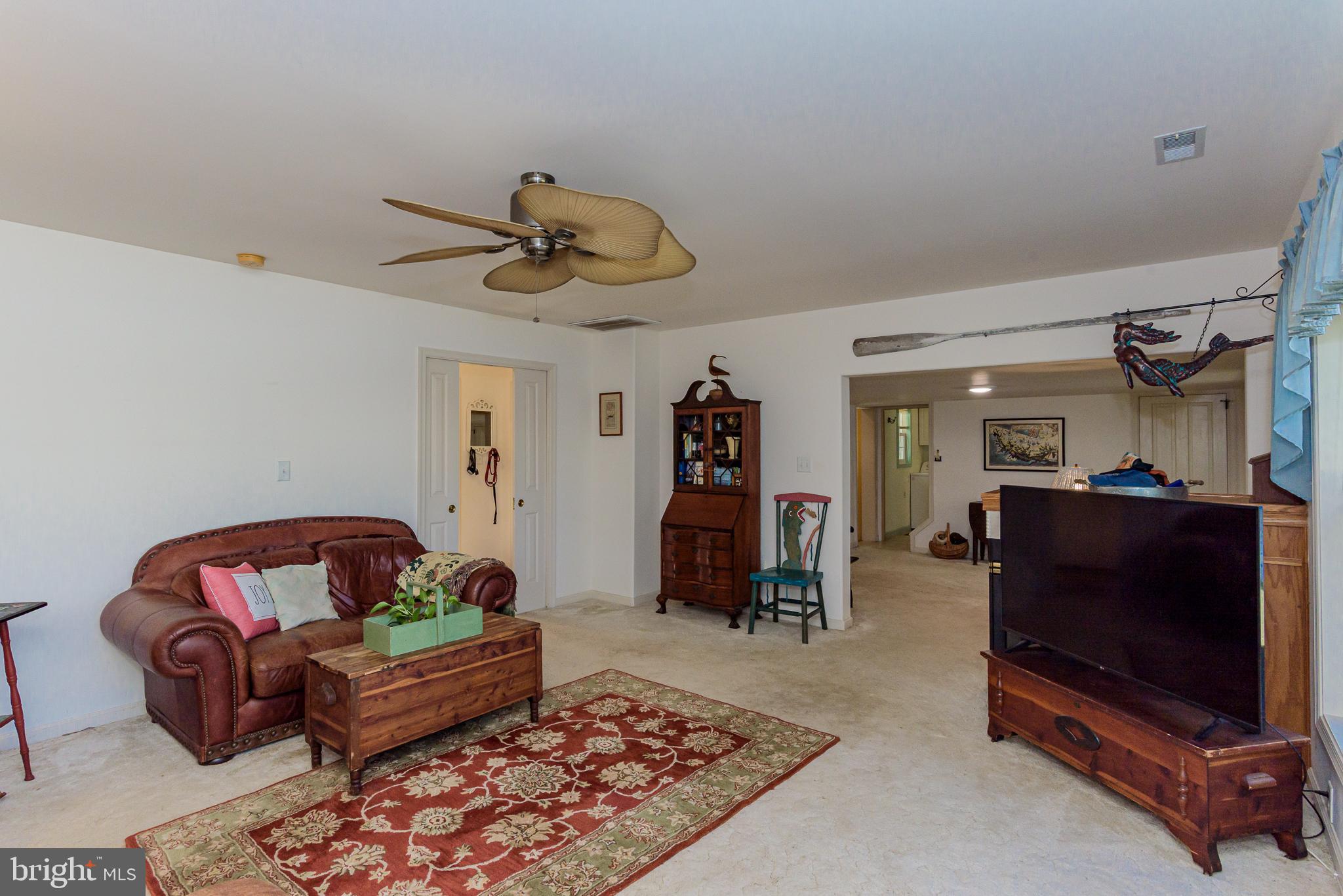 26388 Mt Vernon Road Princess Anne, MD 21853 - Photo 24 of 43 a living room with furniture a flat screen tv and a ceiling fan