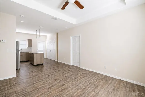 a room with kitchen island stainless steel appliances wooden floor and window