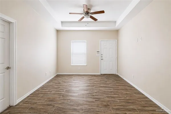 an empty room with fan and windows