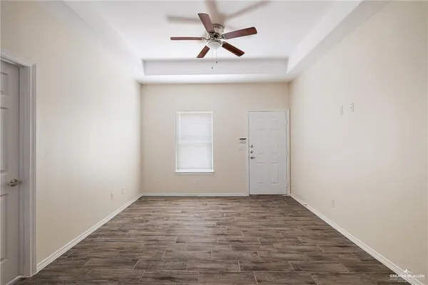 an empty room with fan and windows