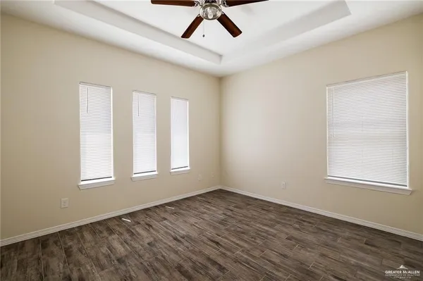 an empty room with windows and fan