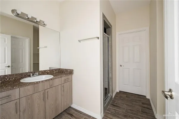 a bathroom with a granite countertop sink and a mirror