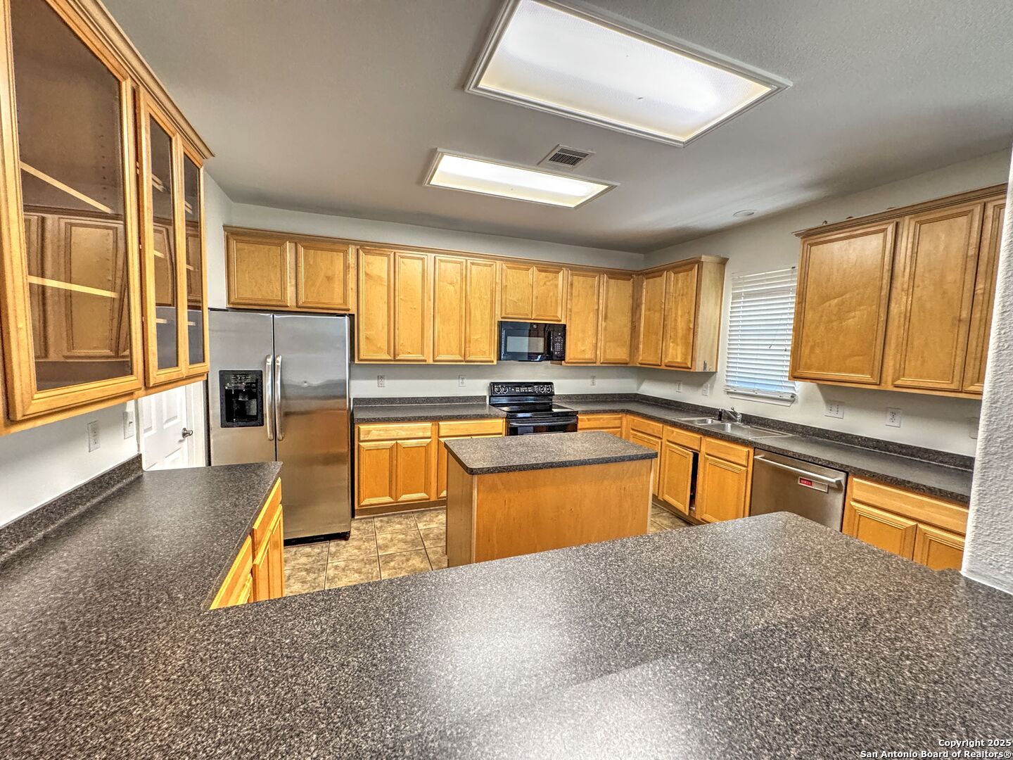 8711 Sandia Circle Helotes, TX 78023 - Photo 15 of 40 a kitchen with stainless steel appliances granite countertop sink stove and large window