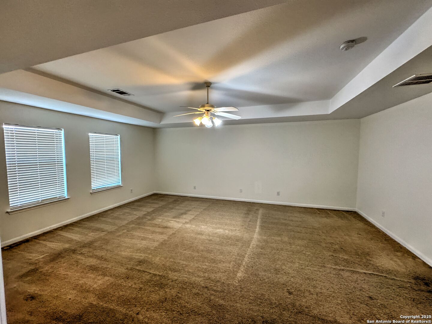 8711 Sandia Circle Helotes, TX 78023 - Photo 19 of 40 a view of an empty room with chandelier fan and fire place