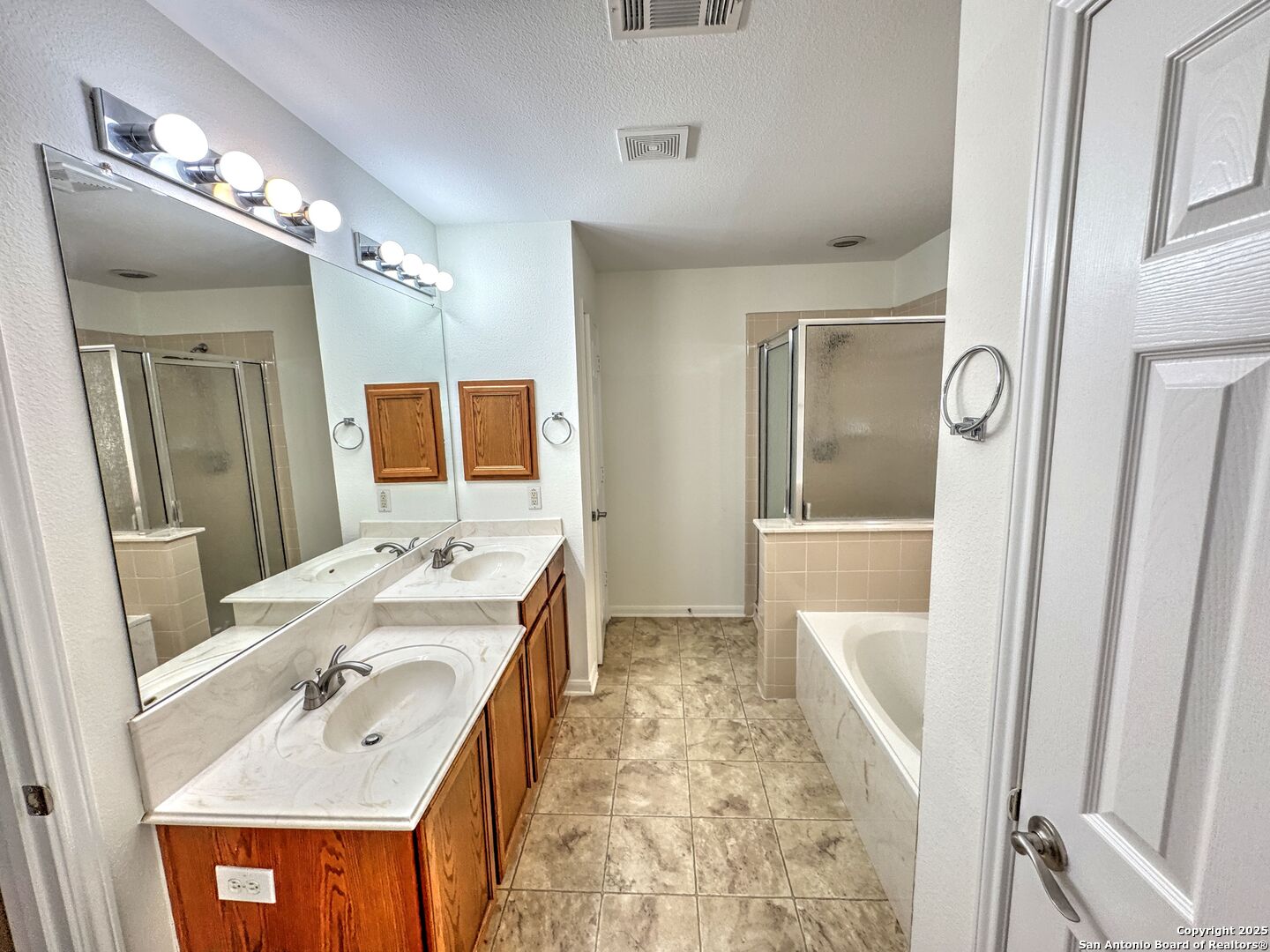8711 Sandia Circle Helotes, TX 78023 - Photo 20 of 40 a bathroom with a tub sink and mirror