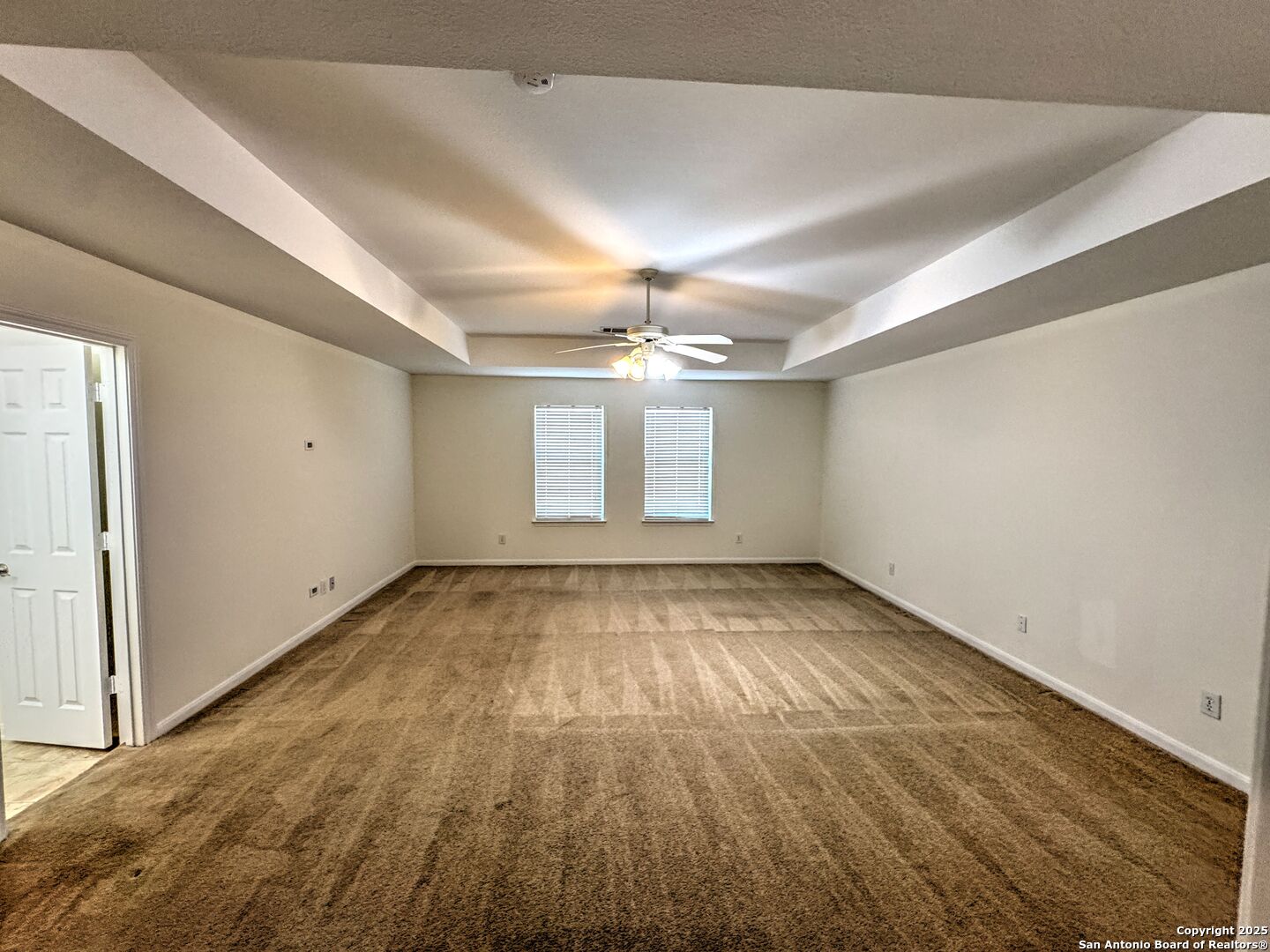 8711 Sandia Circle Helotes, TX 78023 - Photo 26 of 40 an empty room with a chandelier fan and windows