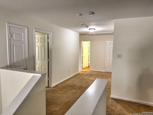 an empty room with a window and a ceiling fan