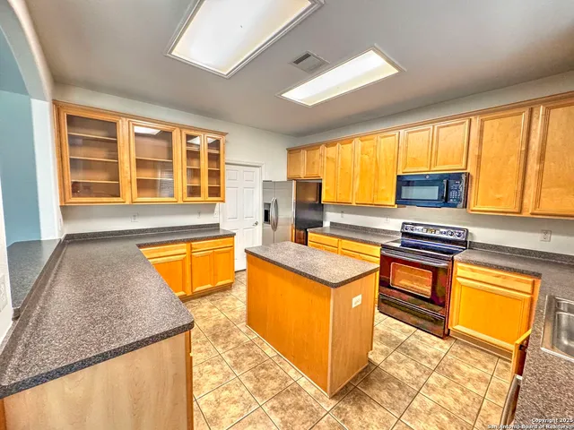 a kitchen with stainless steel appliances granite countertop sink stove top oven and cabinets