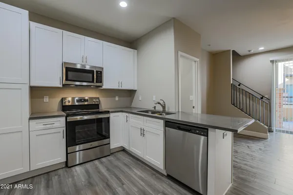 a kitchen with stainless steel appliances granite countertop a stove a sink and a microwave