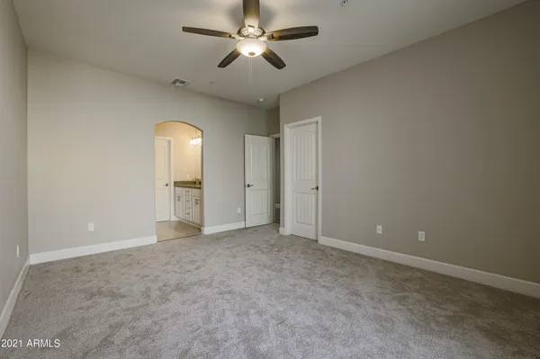 an empty room with closet and a ceiling fan