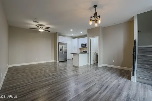 a view of a kitchen with a ceiling fan hardwood floor and a kitchen