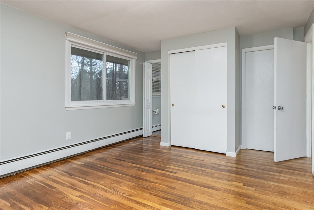 7 No Name Road Stow, MA 01775 - Photo 24 of 42 a view of an empty room with wooden floor and a window