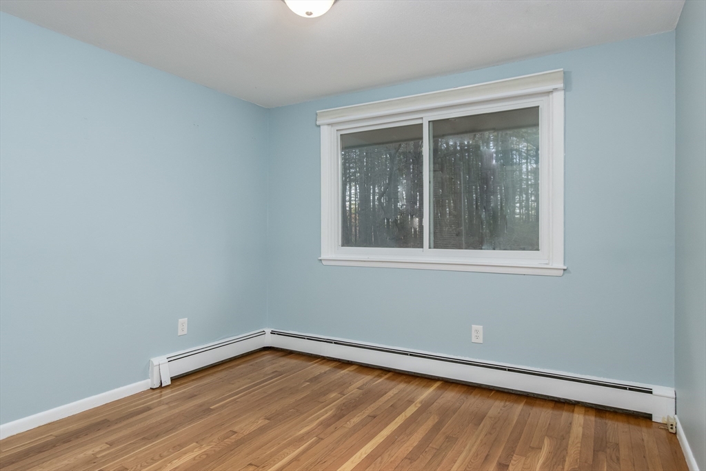 7 No Name Road Stow, MA 01775 - Photo 27 of 42 a view of an empty room with wooden floor and a window