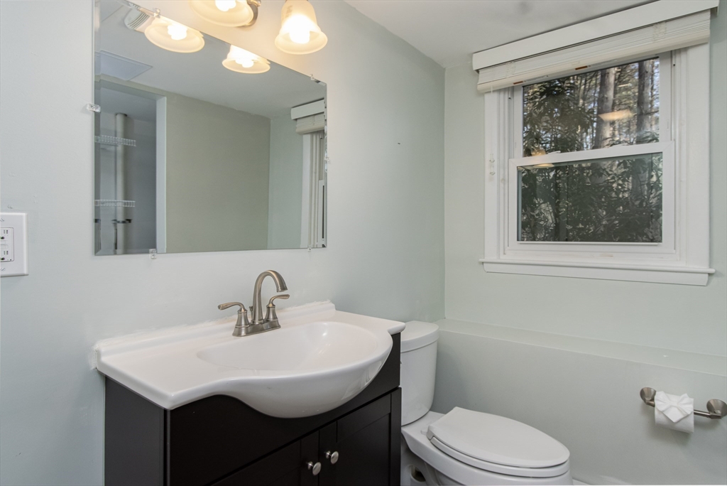 7 No Name Road Stow, MA 01775 - Photo 32 of 42 a bathroom with a toilet a sink a mirror and a window