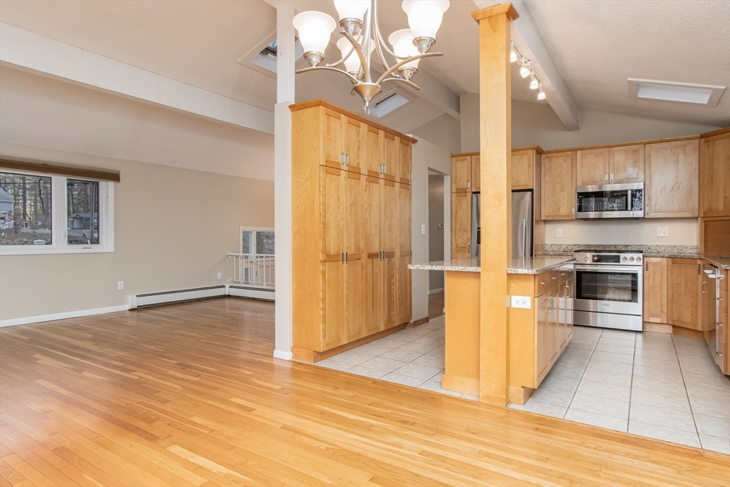 7 No Name Road Stow, MA 01775 - Photo 9 of 42 a view of kitchen with stainless steel appliances kitchen island empty cabinets and wooden floor