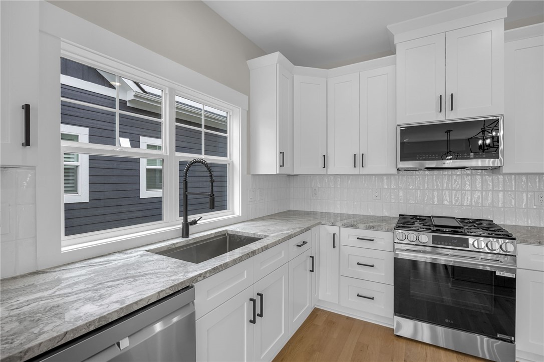 1230 Melton Road, Unit 216 West Union, SC 29696 - Photo 8 of 49 White cabinetry, elegant stone counters, and durable wood flooring adorn this functional kitchen.