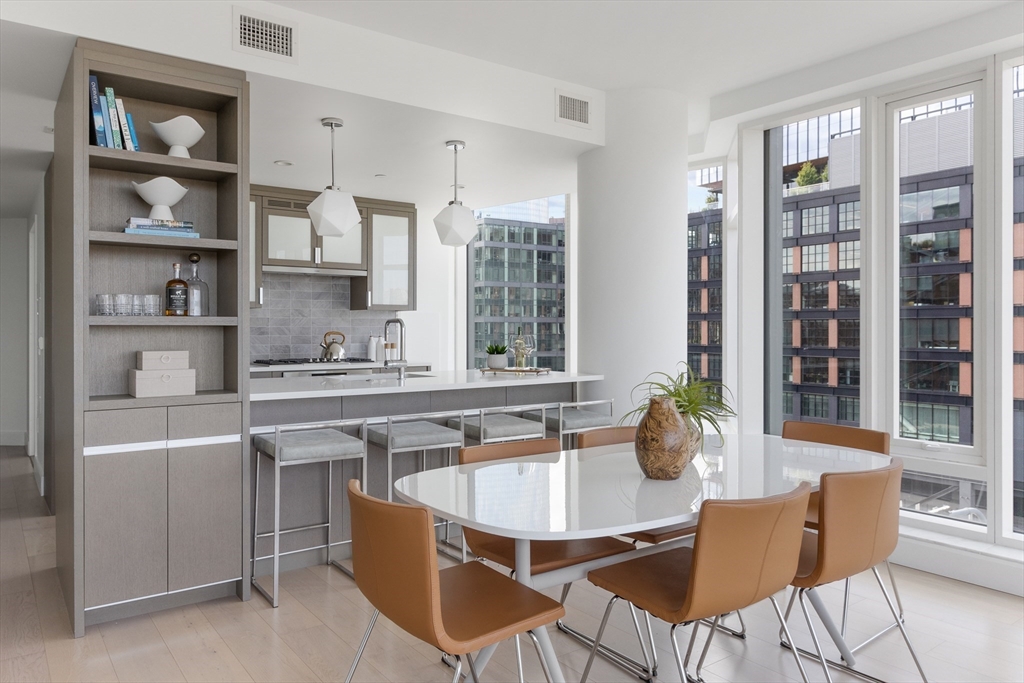 100 Lovejoy Wharf, Unit PH1D Boston, MA 02114 - Photo 6 of 34 a dining room with stainless steel appliances kitchen island granite countertop a table and chairs