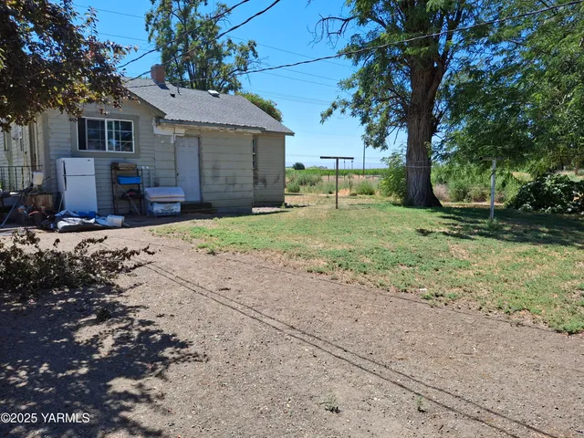 a view of a yard with a house and a tree