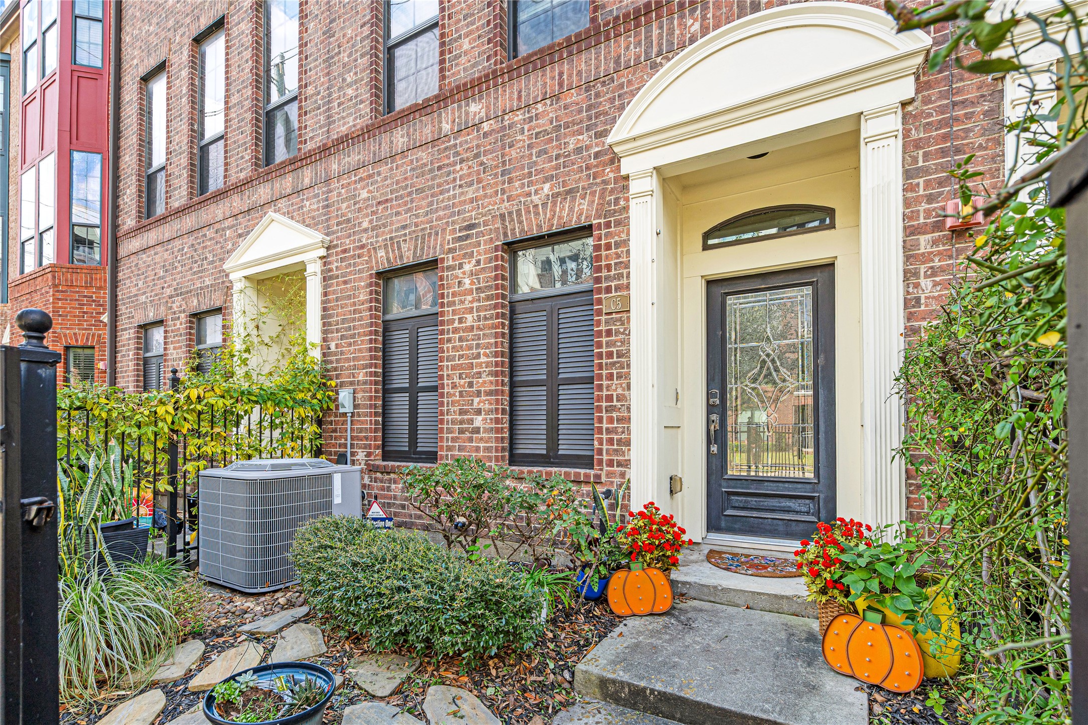 a front view of a house with a chairs and potted plant