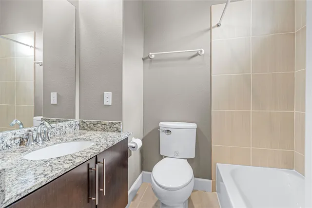 a bathroom with a granite countertop toilet a sink and a mirror