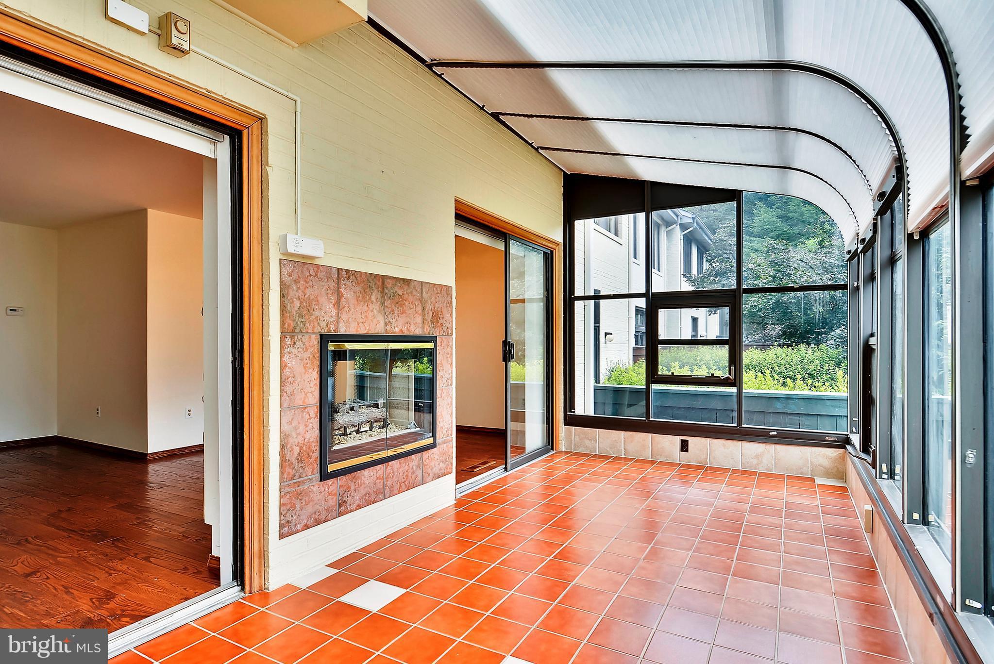 2019 Sarazen Place Reston, VA 20191 - Photo 13 of 30 Sunroom enjoys natural light and 2-sided fireplace