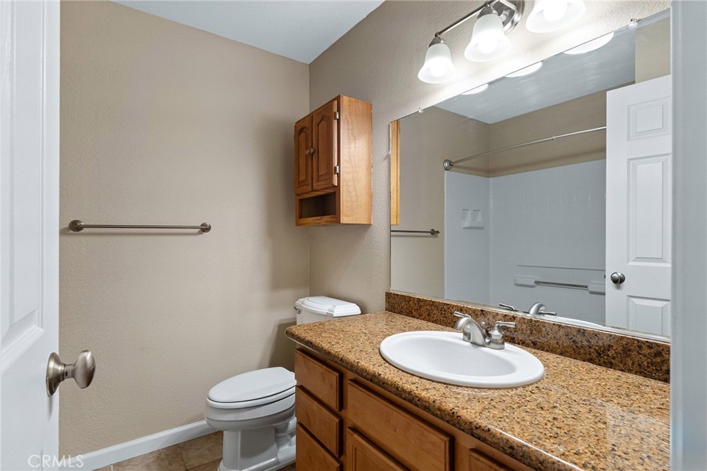 1114 Nord Avenue, Unit 17 Chico, CA 95926 - Photo 17 of 40 a bathroom with a granite countertop sink toilet and a mirror