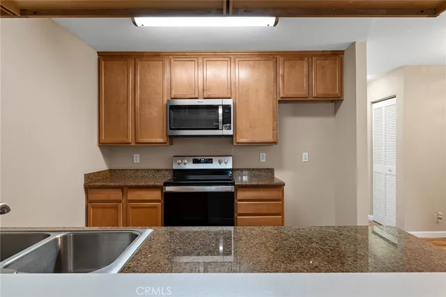 a kitchen with stainless steel appliances granite countertop a sink stove and cabinets