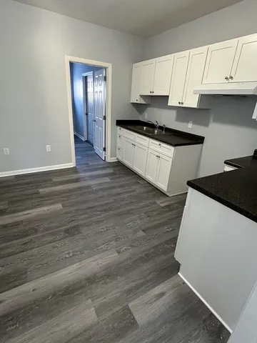 a kitchen with granite countertop a stove and cabinets