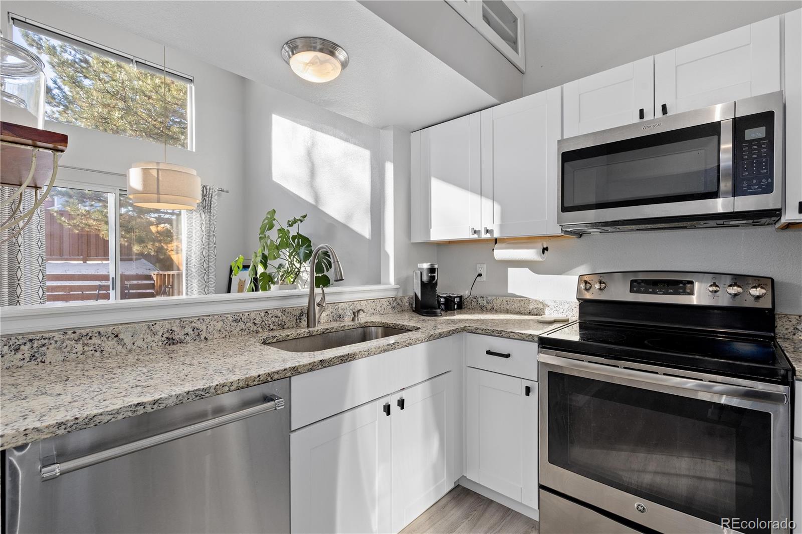 9364 Cattail Court Highlands Ranch, CO 80126 - Photo 12 of 31 a kitchen with a sink stove and microwave