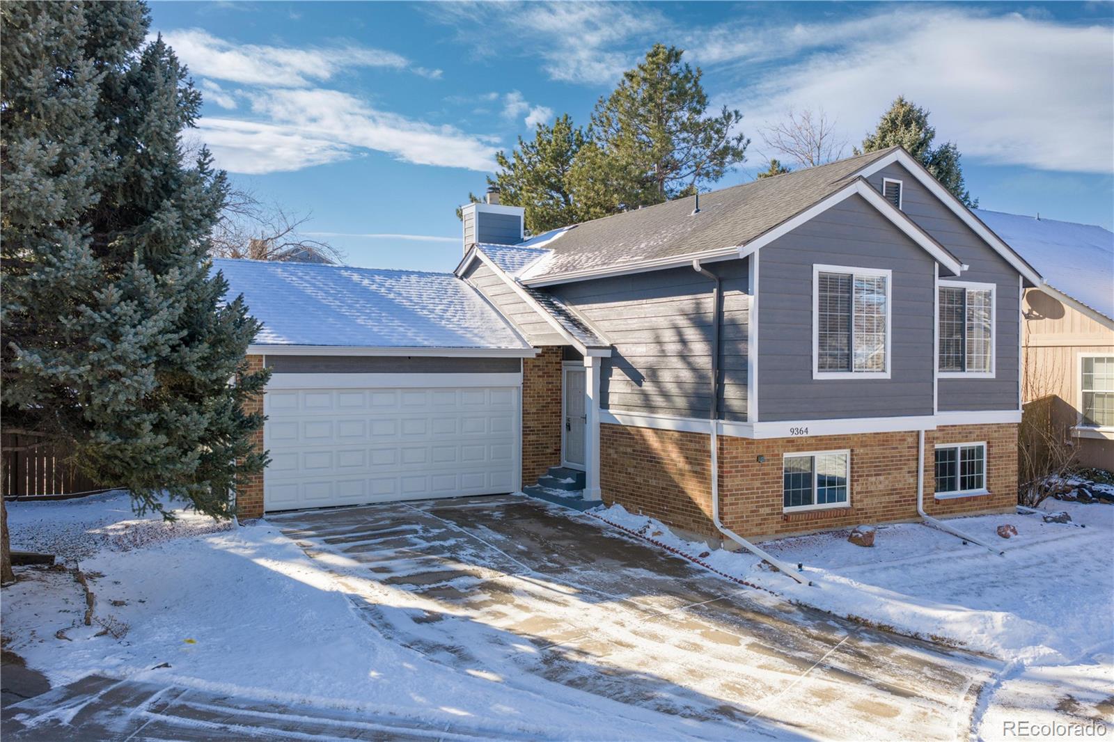 9364 Cattail Court Highlands Ranch, CO 80126 - Photo 2 of 31 a front view of a house with a yard and garage