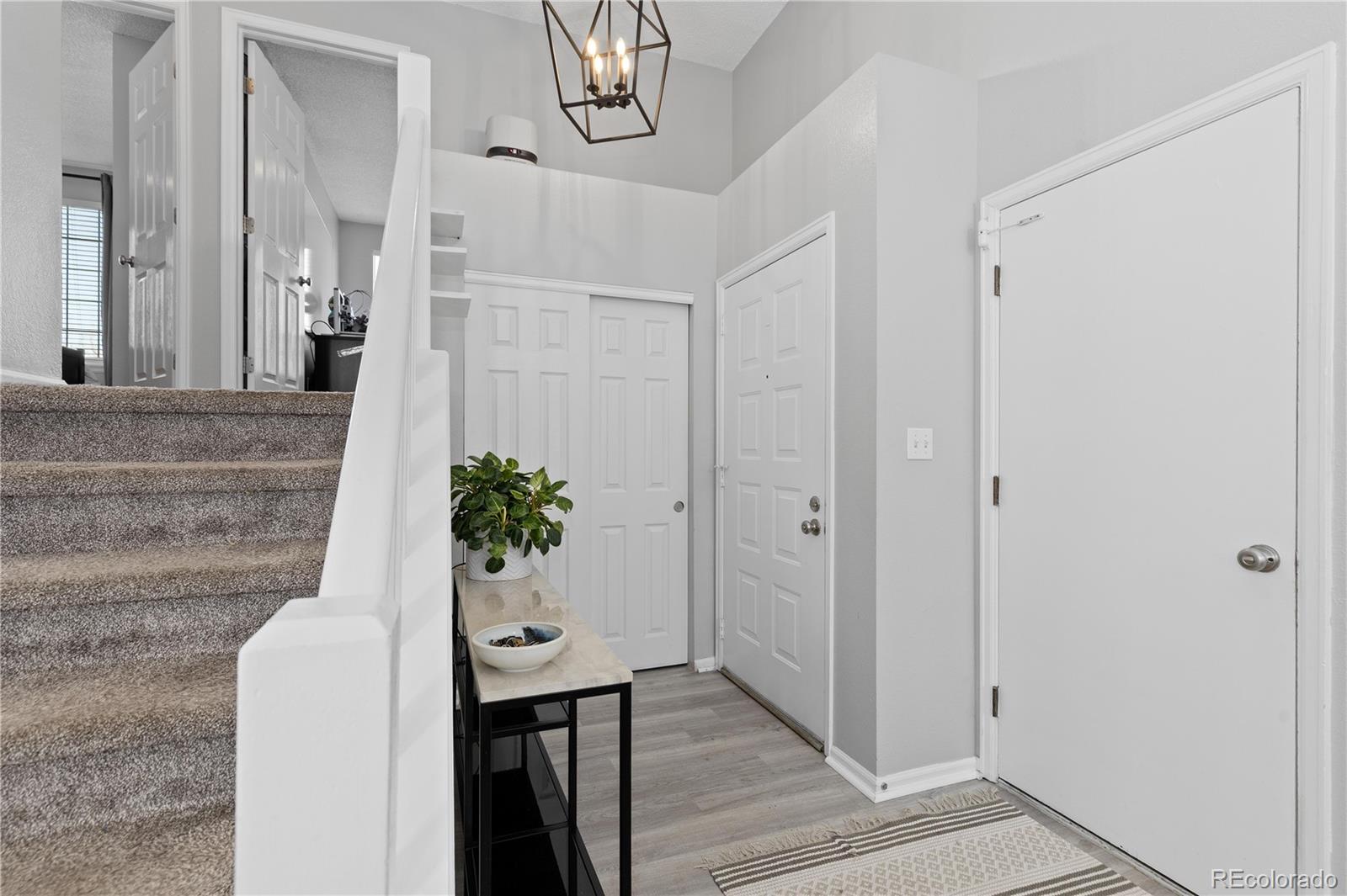 9364 Cattail Court Highlands Ranch, CO 80126 - Photo 4 of 31 a living room with furniture and a chandelier