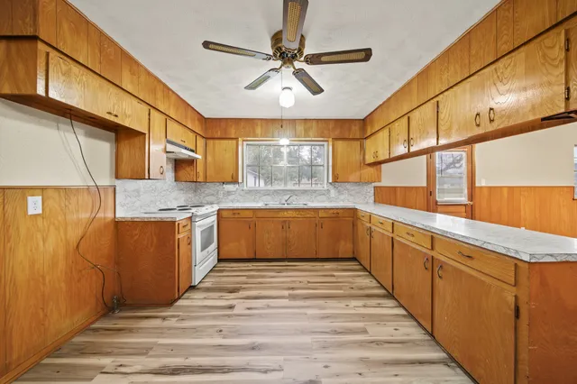 a large kitchen with stainless steel appliances granite countertop a sink and cabinets