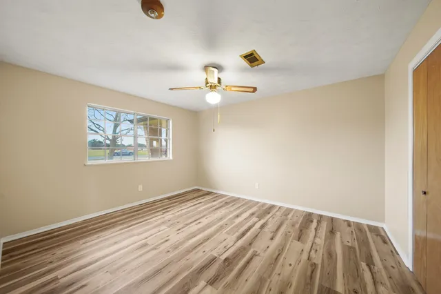 a view of empty room with wooden floor