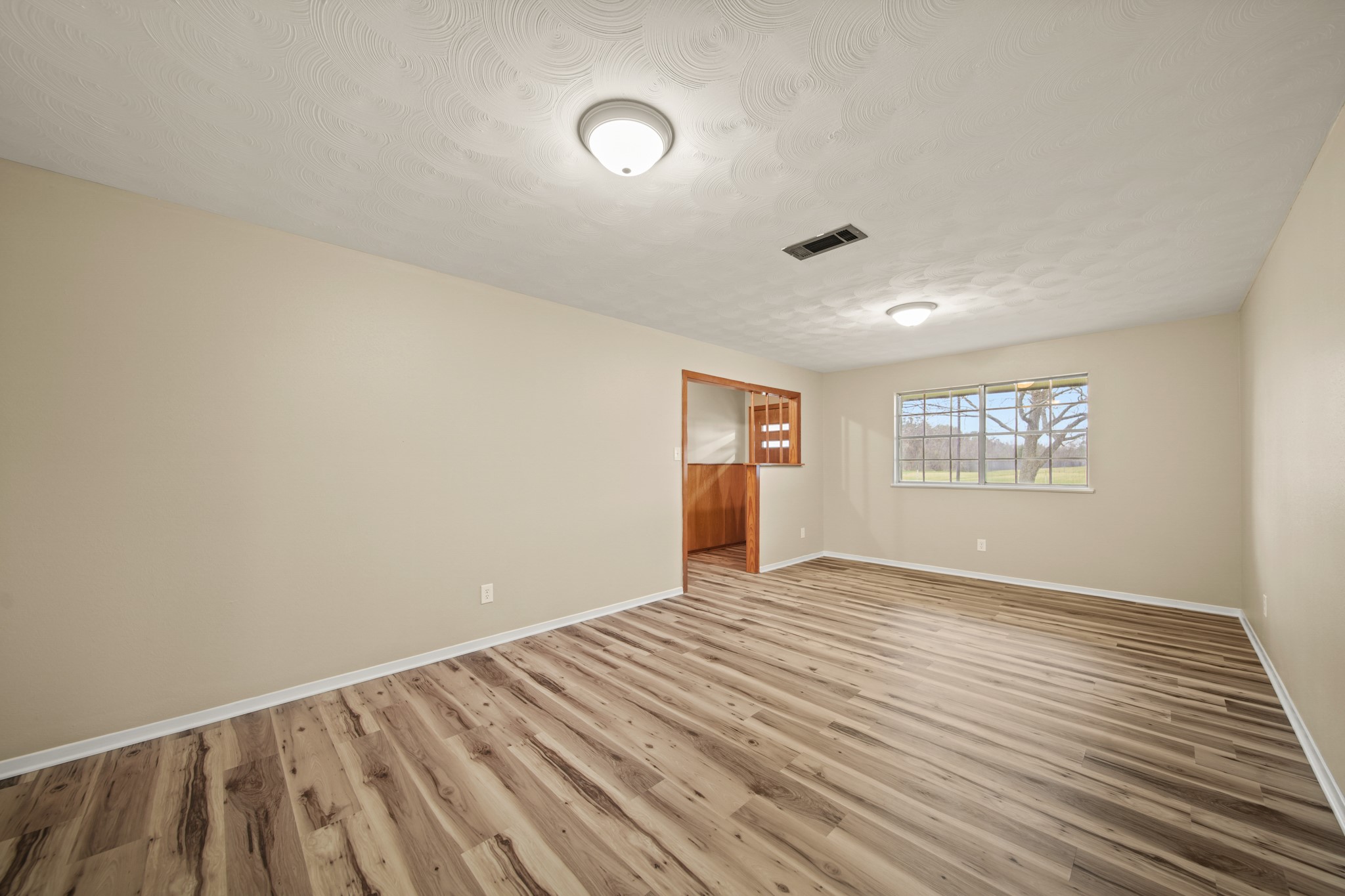 1438 County Road 348 Brazoria, TX 77422 - Photo 9 of 25 a view of an empty room with wooden floor and a window